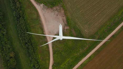 Aerial-drone-top-down,-downward-view-of-a-rotating-wind-turbine