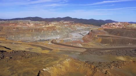 Heavy-machinery-working-in-te-riotinto-open-pit-copper-mine-aerial-shot