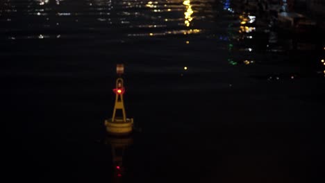 Gelbe-Meeresboje-Mit-Rotem-Licht,-Das-Nachts-Im-Wasser-Schwimmt
