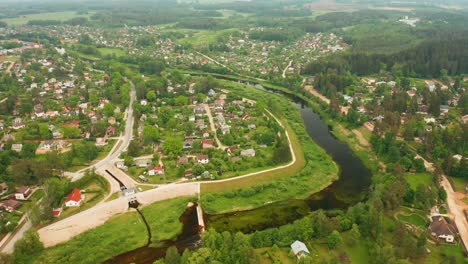 Vista-Panorámica-De-Un-Pequeño-Pueblo-Verde-De-Ogre-En-Letonia-Con-Un-Río-Y-Una-Presa