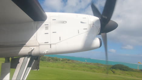 POV-aircraft-window-showing-propeller-and-runway-Lord-Howe-Island-Australia-with-landing-gear-retracting