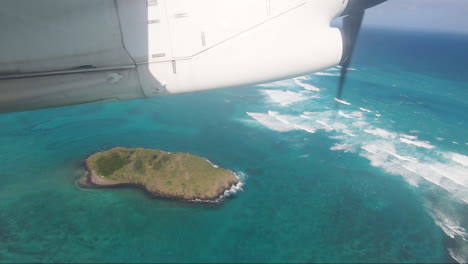 Small-commuter-aircraft-flying-over-Rabbit-Island-Lord-Howe-Island-POV-aircraft-window-showing-shadow-of-aircraft-flying-over-small-island-in-blue-lagoon-Lord-Howe-Island-Australia