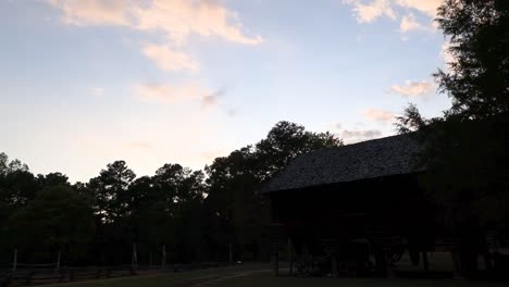 Time-lapse-of-the-sun-setting-over-a-cotton-mill-at-a-farm