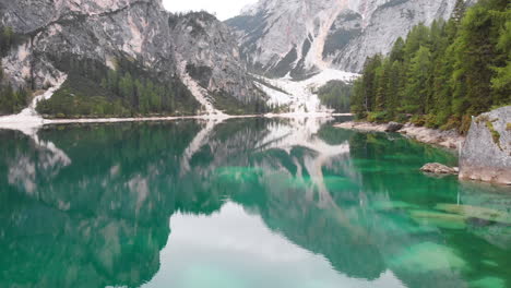 Aerial-drone-shot-over-lake-Braies-revealing-the-beautiful-nature-around-it,-Dolomites-Italy