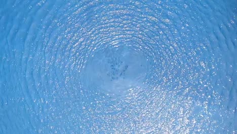 Aerial-view-of-blue-pool-water-rippling-in-slow-motion