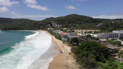 Aerial-view-flying-down-the-beach-at-Noosa-in-Australia-with-the-sea-crashing-in-and-hotels-along-the-front