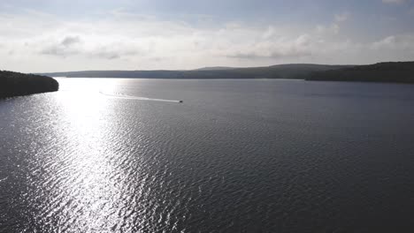 View-moving-towards-boat-driving-on-Lake-Wallenpaupack-from-above