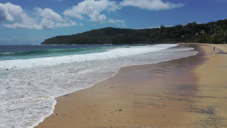 Low-altitude-view-of-the-waves-rolling-in-to-the-beach-at-noosa-with-golden-sand