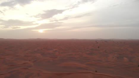 Panoramic-aerial-shot-of-arabian-red-desert-dunes-at-sunset-in-Dubai,-United-Arab-Emirates