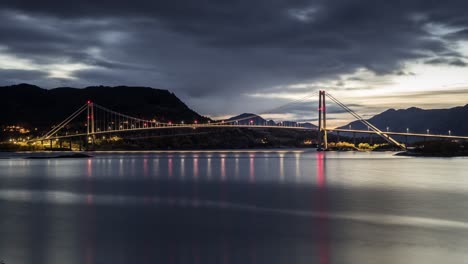 NIght-view-of-the-Gjemnessund-Bridge,-a-bridge-that-crosses-the-Gjemnessundet-strait-between-the-mainland-and-the-island-of-Bergsøya-in-the-municipality-of-Gjemnes-in-Møre-og-Romsdal-county,-Norway