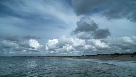 Timelapse-of-clouds-moving-away-from-the-viewer-from-sea-to-land-over-a-beach