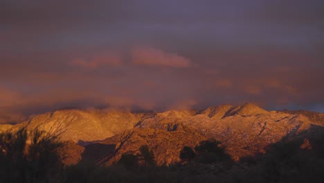 Beautiful-pink-and-orange-sunset-light-on-snow-covered-mountains,-Arizona