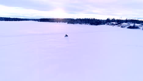 Ein-Schneemobil-Beschleunigt-Auf-Einem-Zugefrorenen-See,-Um-Nach-Hause-Zu-Fahren