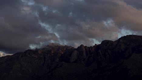 Moody-and-colorful-clouds-over-Catalina-Mountains-at-Sunset,-Arizona,-Dolly-Out