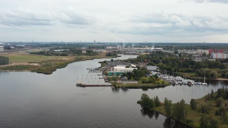 Aerial-panoramic-drone-video-of-a-riverside-marina-on-a-cloudy-day