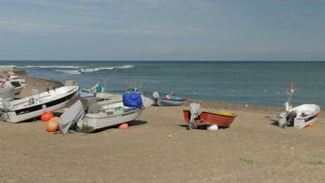 Fisherman-boats-at-the-beach-with-water-in-background-wide-panning-shot