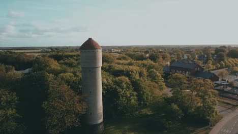 Drone-flying-by-a-tower-in-danish-town,-Ribe