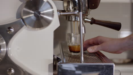A-man-is-making-a-glass-of-espresso-at-an-espresso-machine-during-the-day