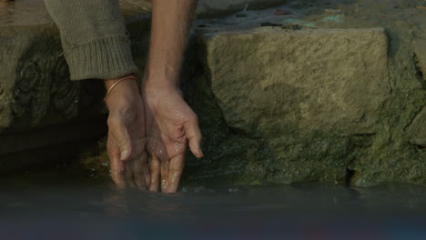 Ein-Mann-Spritzt-Seine-Hände-In-Einen-Fluss