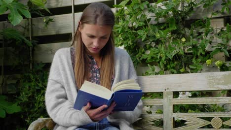 Mädchen-Mit-Langen-Haaren-Sitzt-Lesebuch-Auf-Gartenbank-Im-Freien