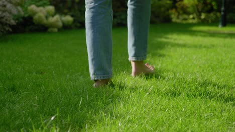 Female-feet-walking-barefoot-on-grass-in-manicured-lawn,-low-angle
