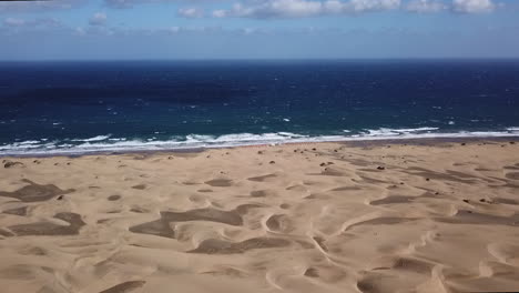 Beach-sand-dunes-drone-flyover-on-a-sunny-windy-day