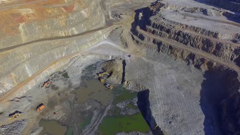 Heavy-machinery-working-in-te-riotinto-open-pit-copper-mine-aerial-shot