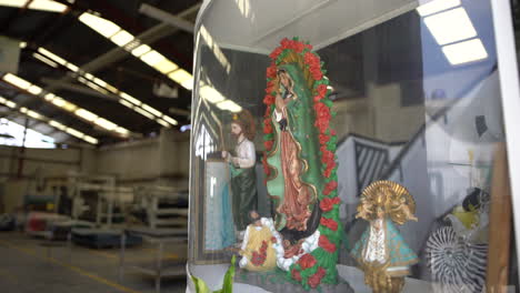 A-slow-dolly-in-of-a-Virgin-Mary-and-Catholic-Saints-in-a-Mexican-warehouse---industrial-plant