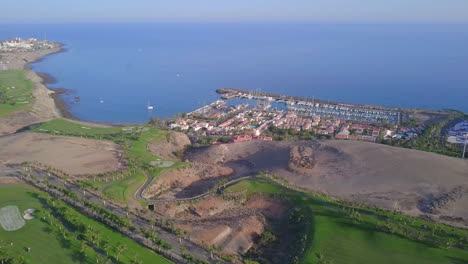 Marina-and-golf-course-drone-flyover-view-sunny-day-on-tropical-island