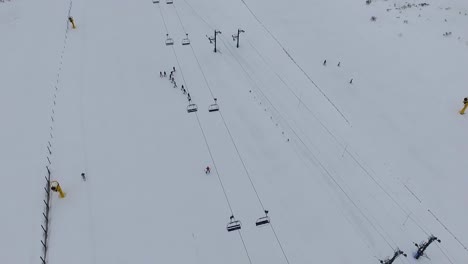 Leerer-Sessellift-Und-Menschen,-Die-Im-Altcampoo-skigebiet-Luftaufnahme-Fahren