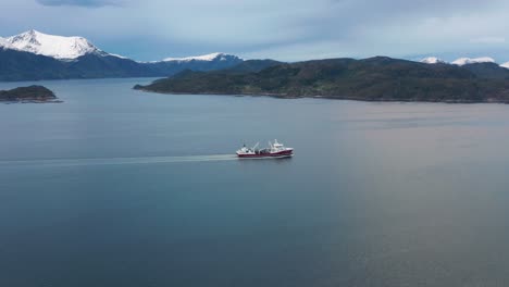 Big-red-and-white-ship-crossing-the-fjord,-leaving-only-low-waves-in-its'-wake