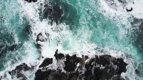 Rising-aerial-of-rocky-coastline-with-waves-surging-and-breaking-over-rocks,-Cape-Schanck,-Mornington-Peninsula