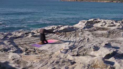 Frau-Beim-Yoga-Auf-Einer-Meeresklippe-Bei-Sonnenaufgang