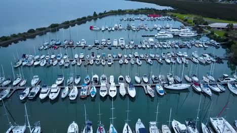 Aerial-shot-of-luxury-boats-moored-in-tranquil-marina-on-a-calm-day
