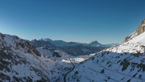 Un-Camino-Estrecho-Que-Serpentea-Entre-Los-Picos-Montañosos-Cubiertos-De-Nieve-Que-Conducen-Al-Passo-Falzarego-En-Los-Dolomitas-Italianos