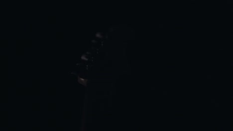 Light-revealing-guitar-element-in-complete-darkness