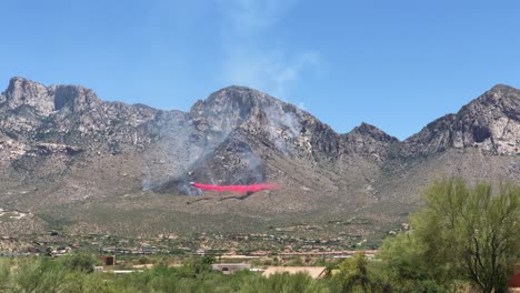 Firefighters-Airplane-Flying-Under-Wildfire-Dropping-Retardant-Preventing-Spread-in-Valley-Under-Mountain-Hills