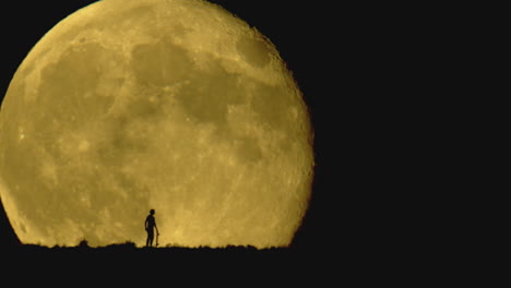 A-person-standing-in-front-of-the-moon