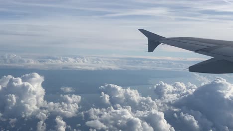 Flugzeugfensteransicht-Des-Flügels-Und-Schöne-Flauschige-Wolken-An-Einem-Sonnigen-Tag