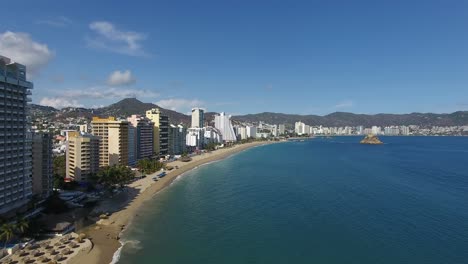 Toma-Aerea-Con-Drone-De-La-Bahia-De-Acapulco-Donde-Se-Ve-La-Playa,-El-Mar-Y-Los-Hoteles