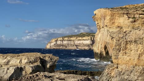 Waves-crash-limestone-cliffs,-Blue-Hole,-Gozo,-site-of-former-Azure-Window