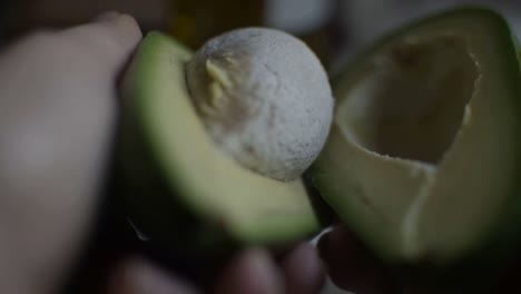 Dividing-a-green-avocado-in-two-pieces-after-cutting-it
