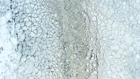 Aerial-fly-over-view-of-cracked-ice-floes-floating-in-the-sea