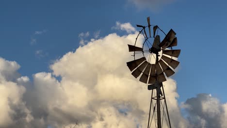Alte-Kaputte-Windmühle-Gegen-Weiße-Wolken-Und-Blauen-Himmel---Handheld