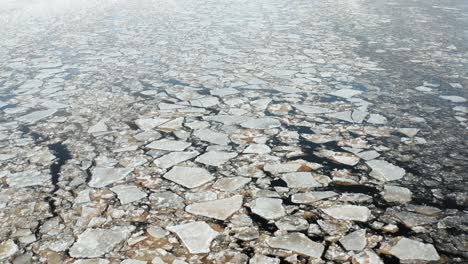 Beautiful-aerial-fly-over-view-of-cracked-ice-floes-floating-in-the-sea