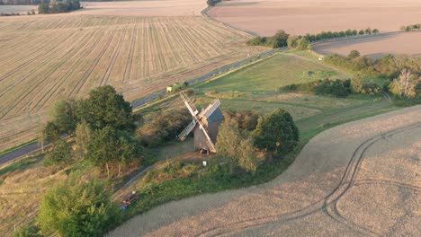 Die-Alte-Windmühle,-Die-Irgendwo-In-Deutschland-Auf-Der-Grünen-Parche-Steht,-Umgeben-Von-Ackerfeldern