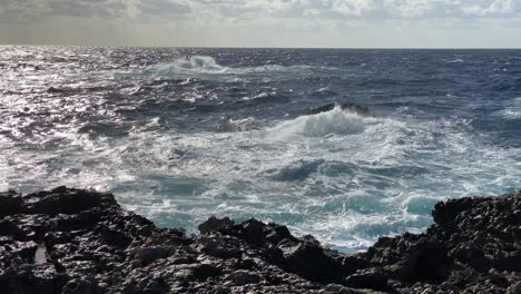 Waves-crash-and-churn-as-the-sea-batters-the-rocky-Maltese-coastline,-slow-mo