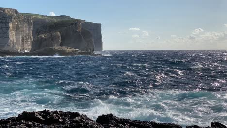 Vista-Sobre-El-Soleado-Mar-Azul-Inquieto-Hacia-La-Roca-Fungosa-Y-La-Bahía-De-Dwejra,-Gozo-Malta