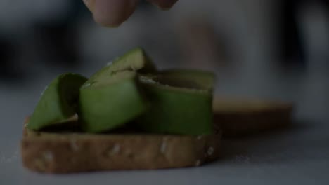 Putting-some-salt-and-squeezing-a-lemon-on-the-freshly-made-avocado-toast