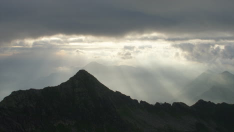 Sonnenstrahlen-Durch-Die-Wolken-über-Bergrücken-Bei-Sonnenaufgang